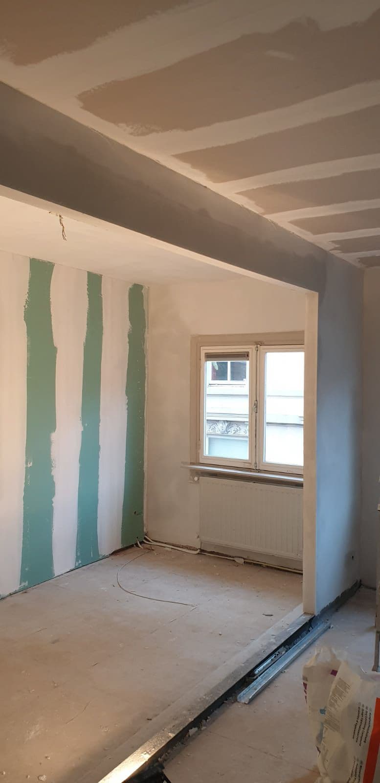Dezelfde slaapkamer met nieuwe gipsplaatwanden, gevoegd en klaar voor renovlies
