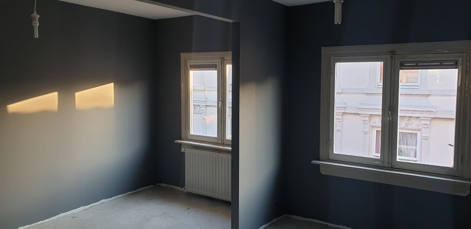 De slaapkamer na de renovatie: strakke wanden met renovlies in een donkerblauwe latex