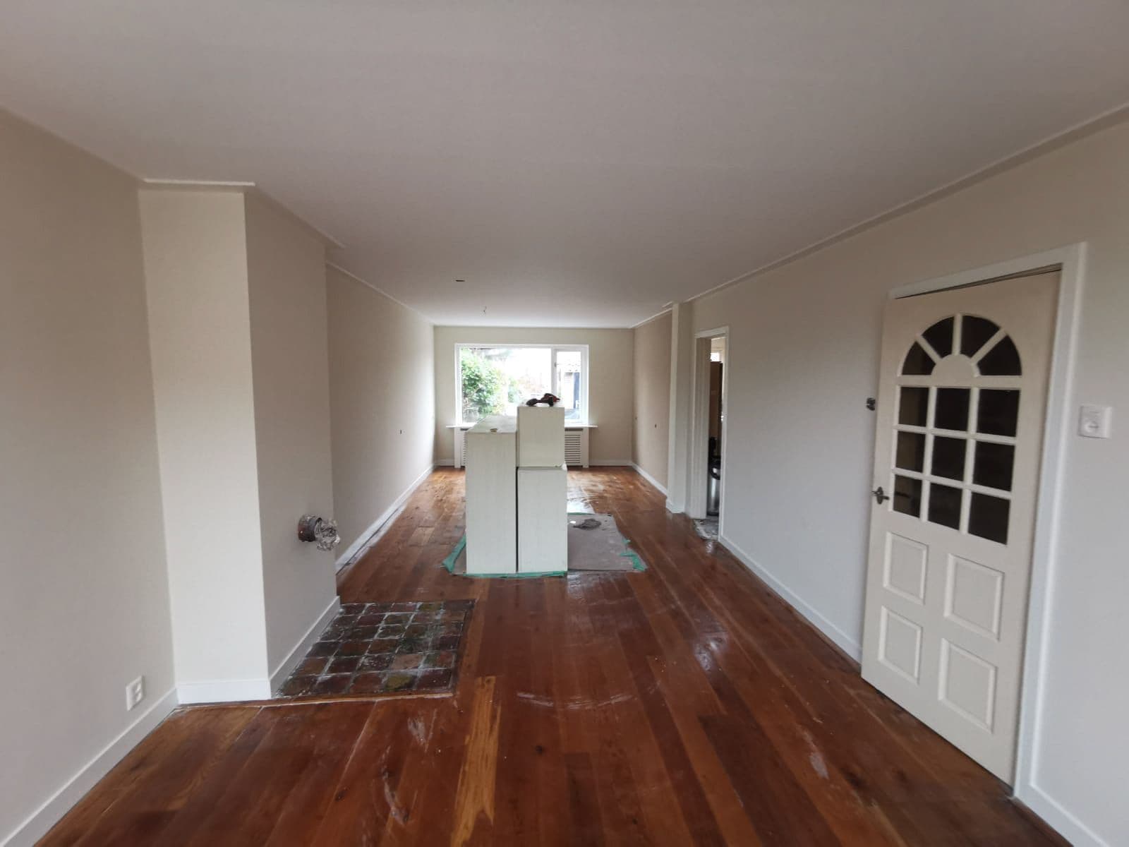 Dezelfde woonkamer na de renovatie: strakke lichte wanden met renovlies en latex